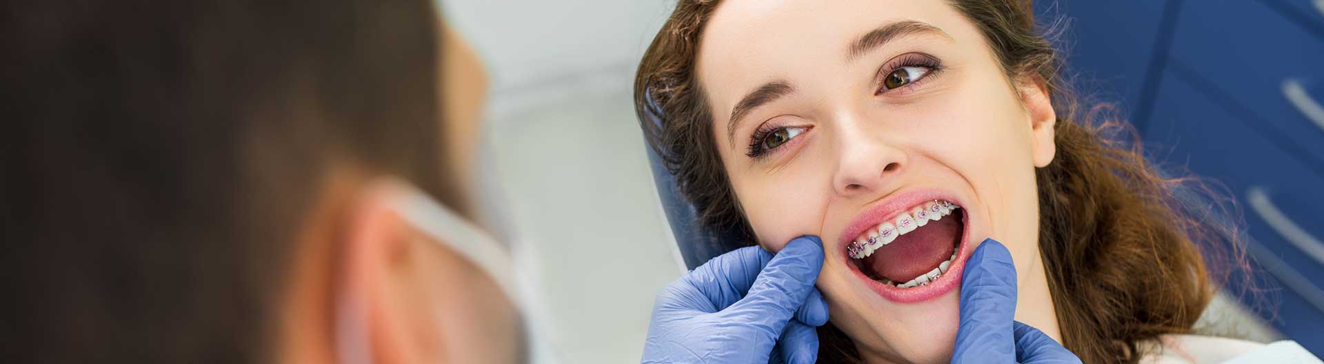 A dentist is adjusting a patient's braces