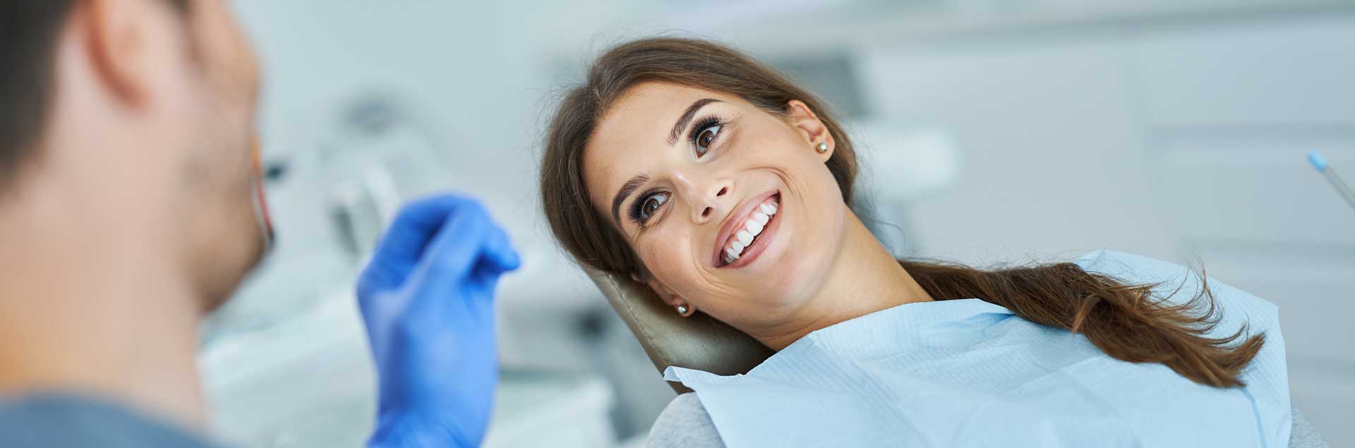 A patient is smiling at the dentist prior to the treatment